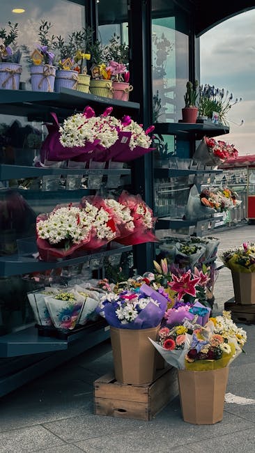 A display of fresh floral arrangements at flowersbasildon.co.uk, featuring vibrant bouquets of daisies, lilies, and carnations in shades of white, pink, purple, and yellow, wrapped in colorful paper a
